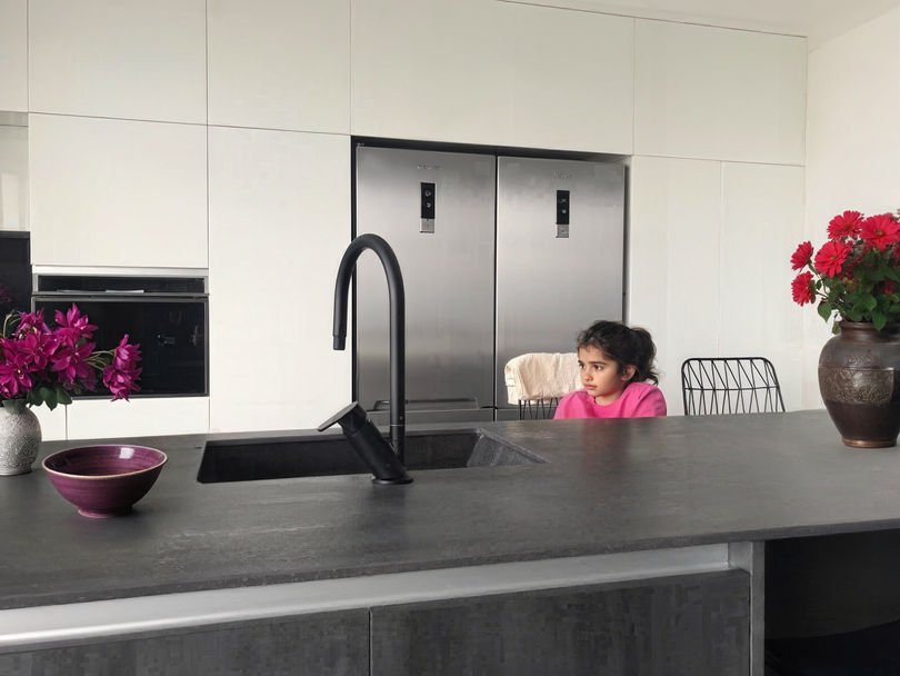 ילדה יושבת על האי במטבח