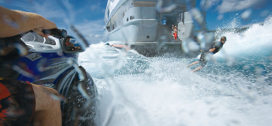 Shot of waterskier being towed by a yacht as viewed from the passenger seat of a jetski