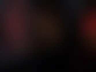 Erwachsene Frau liest Dark Romance online in dunklem Regenzimmer mit rotem Licht und Smartphone