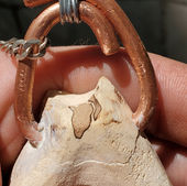 Close up detail shot of a hand crafted wooden amulet made of eucalyptus wood. Every part of the wood grain captured in exquisite detail