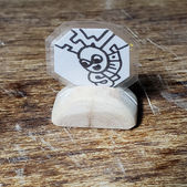 Collectable coin artwork featuring a cartoon character. The art sits on a hand crafted wooden base made from eucalyptus wood. Created by IW Comics .Shop