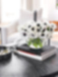 Luxury home styling with white anemone floral arrangement and designer coffee table books by San Diego interior designer