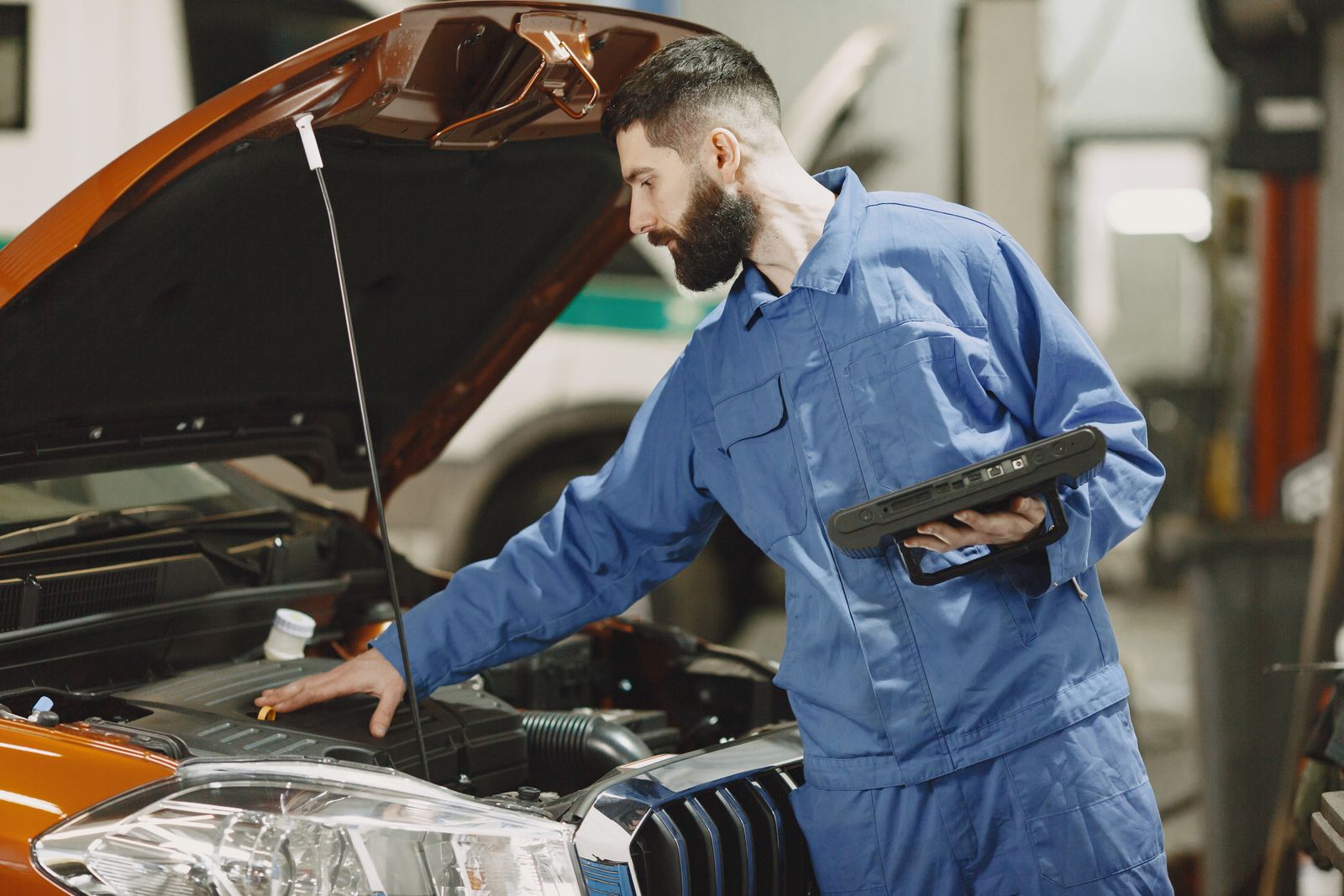 Real mechanic inspecting an engine in an automotive workshop