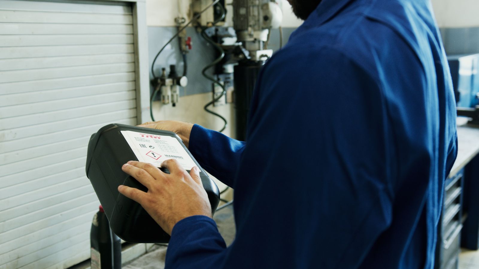 Real mechanic using vehicle diagnostic equipment in an auto workshop