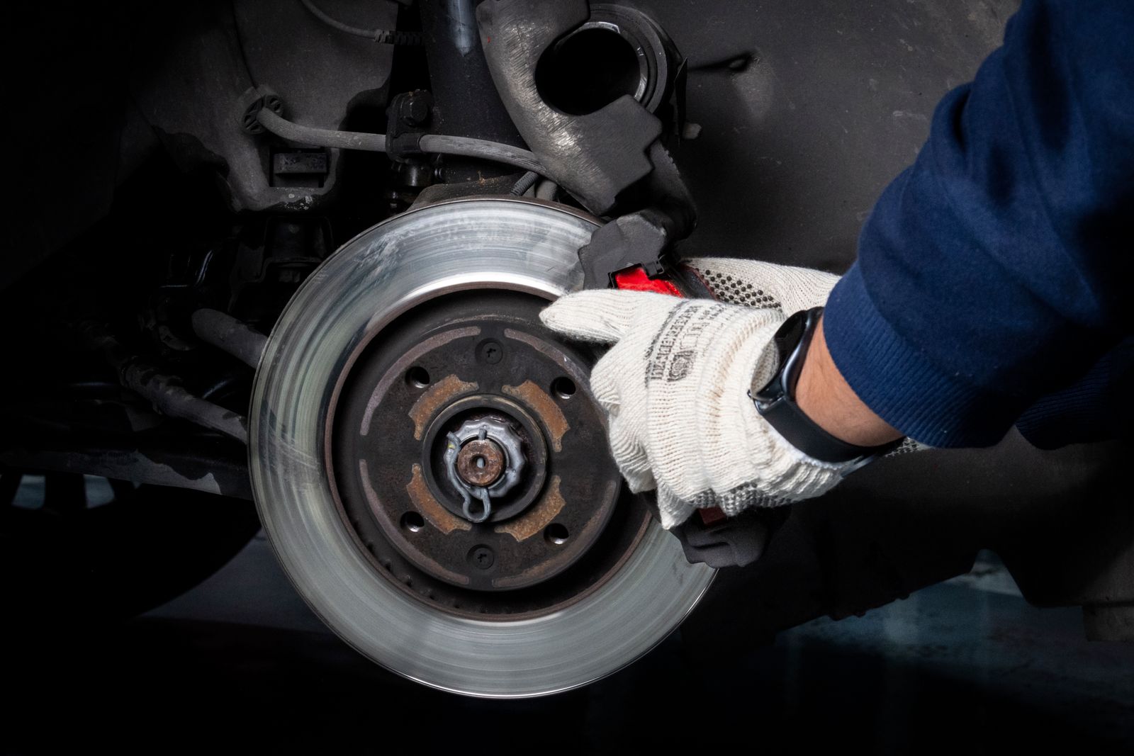Real brake service with mechanic working at the rotor and caliper