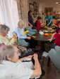 care home residents and school children sewing daffodil cushions