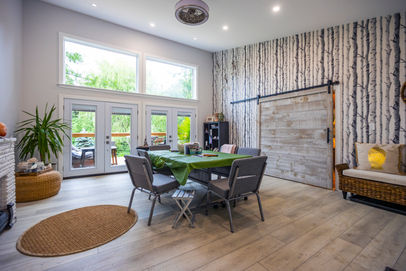 Bright modern room with dining area, large windows, and birch wall.