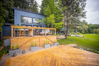 Modern blue house with large wooden deck and outdoor seating