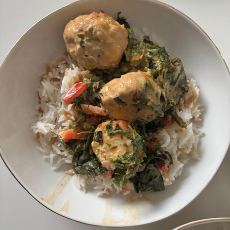 Baked chicken meatballs in a light coconut curry with ginger, red pepper, and greens. A healthy Mediterranean-friendly Thai-inspired dinner.