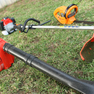 Red gas-powered weed-wacker, blower, and trimmer