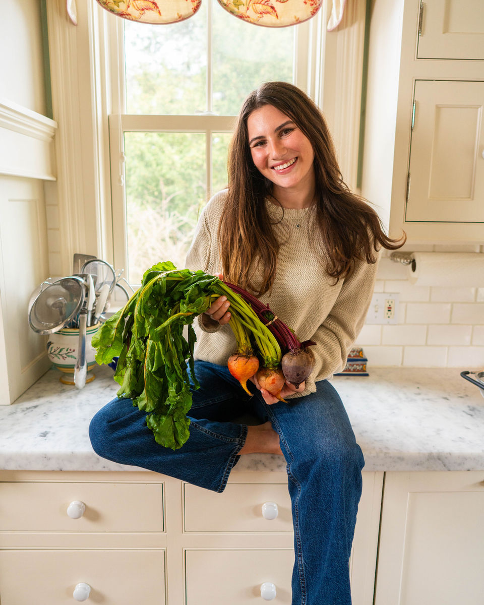 Olivia Robie, MS, RDN, holding fresh beets in her kitchen
