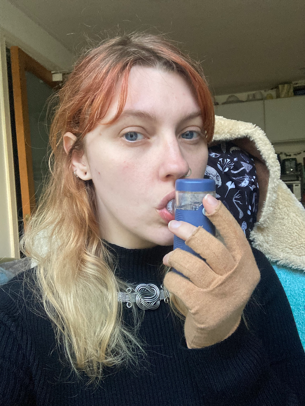 Katja, a woman with ginger to blonde hair is using a Beurer nebuliser without any of the attachments to hydrate her vocal folds. 