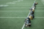 Football helmets on a field | Sam Gash
