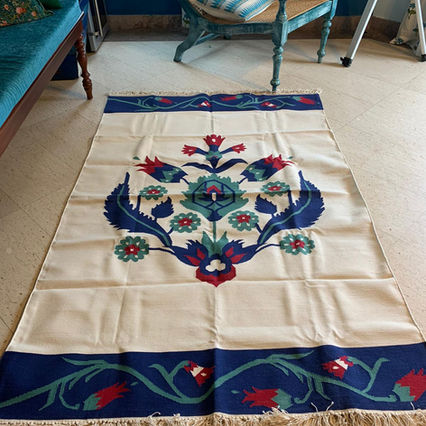 A cotton dhurrie rug inspired by the Iznik pottery in teal, blue and red colours.