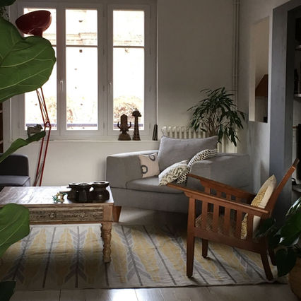 A wool dhurrie rug in beige and mustard colours gracing a French home.