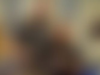 A man and a woman smile while holding a certificate of completion in an office setting. She wears a black uniform with a yellow badge.