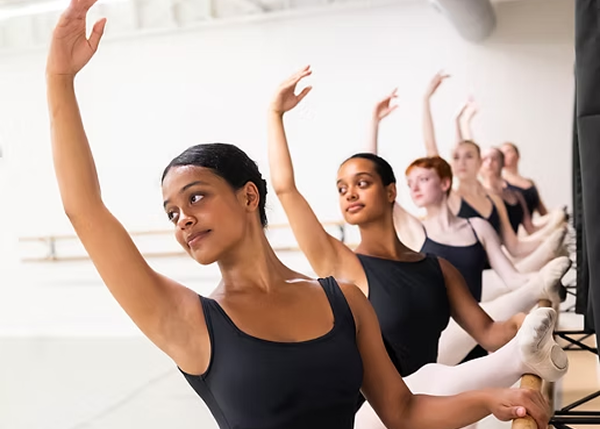 A line of dancers with their hands lifted up