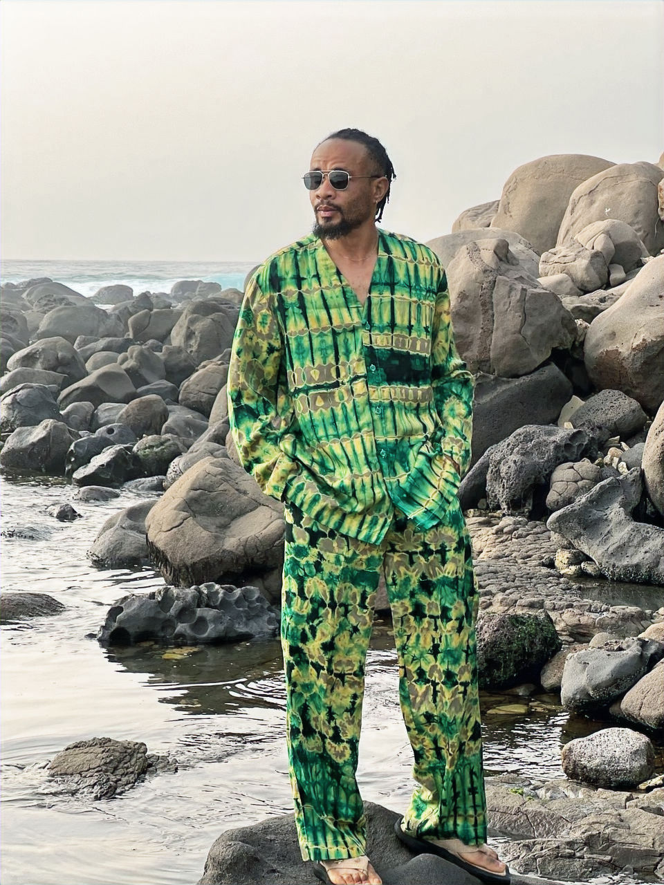 Un homme élégant vêtu d’un dashiki raffiné en tissu africain aux couleurs vives, représentant les vêtements africains hommes 