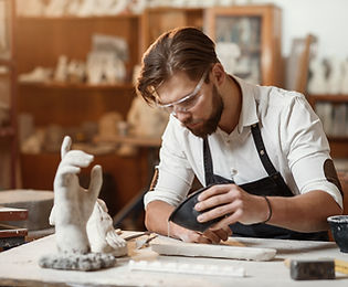 Young sculptor works in a plaster worksh