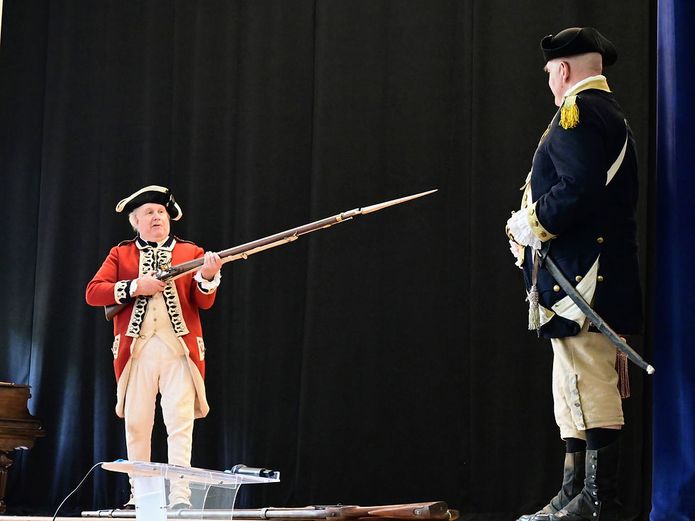 Revolutionary War british soldier reenactor points a long rifle with bayonette