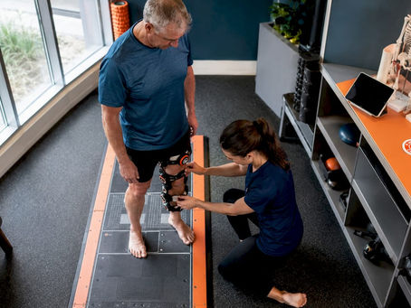 Physiotherapist adjusting APOS device on patient during clinical assessment