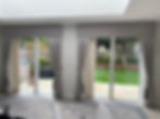 2 sets of patio doors with soft grey floor length curtains, tie backs and pelmets