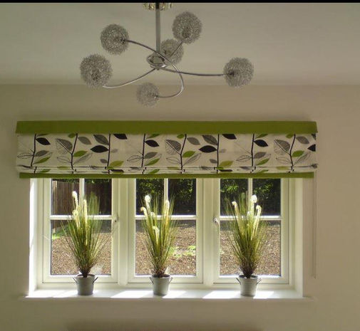 window with white green and grey Roman blind and matching pot plants on sill