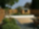 garden with decking and raised planters on sunny day