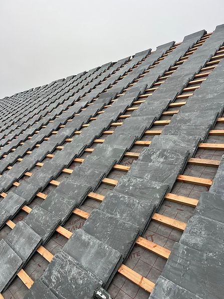 slate tiles neatly stacked in rows ready to be installed on a roof