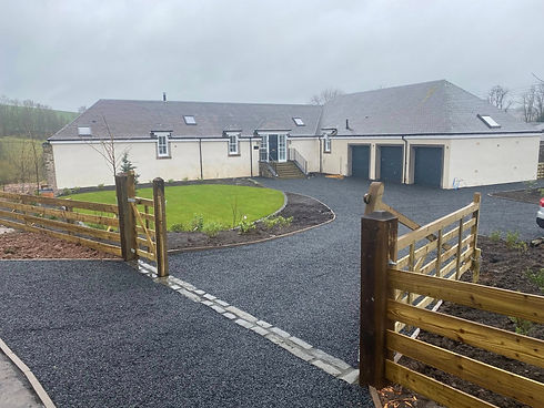 asphalt driveway leading to large bungalow with double garage