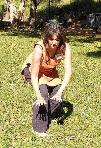 Facilitator Nora Bending Down with Both Hands
