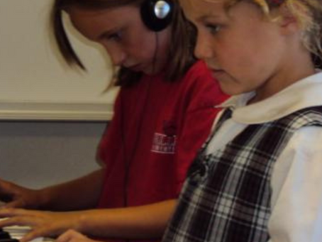 Elementary school girls learning to play piano