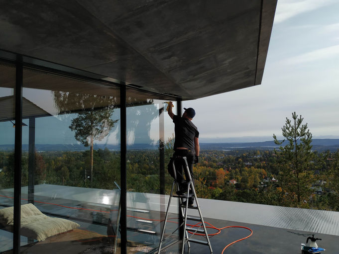 profesjonell vinduspusser i stige vasker panoramavinduer