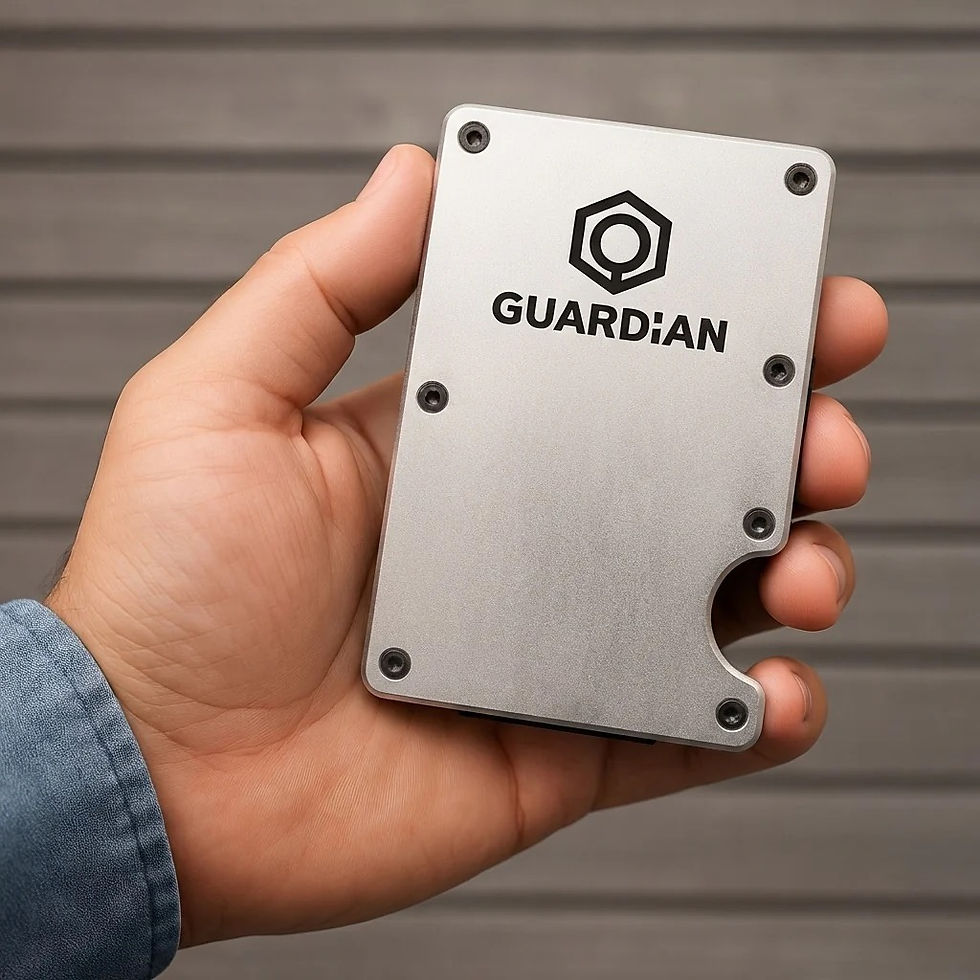 Mano sostiene una cartera metálica plateado con logo y texto GUARDIAN, sobre fondo gris; aspecto moderno.