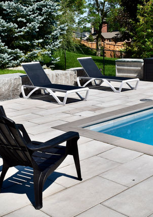 Outdoor dining and lounge seating beside the pool in an East Gwillimbury backyard