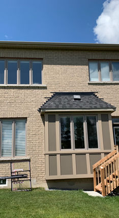 Horvath Landscaping site photo showing the existing rear elevation with upper windows, backyard lawn, and a small deck and stairs.