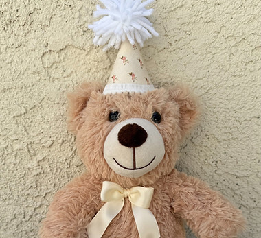 Handcrafted mini fabric bear hats, featuring a fluffy yarn pom-pom on top and decorative bottom trim.