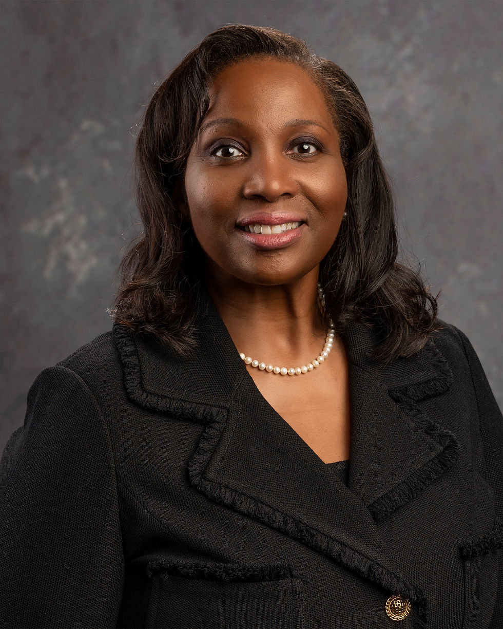 Official portrait of Federal Reserve Governor Lisa D. Cook in a black jacket and pearl necklace against a gray backdrop