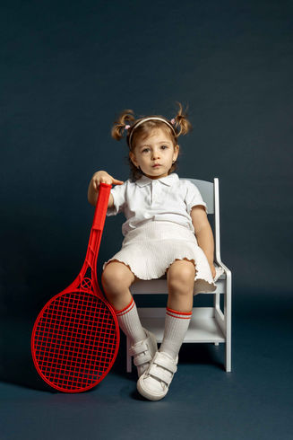 Stylizovaná kids editorial fotografie dítěte se sportovní tenisovou rekvizitou v barevném prostředí. Foto Aneta Ježková