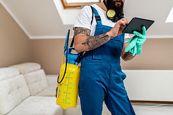 Exterminator in work wear writing annotation about pest extermination plan..jpg