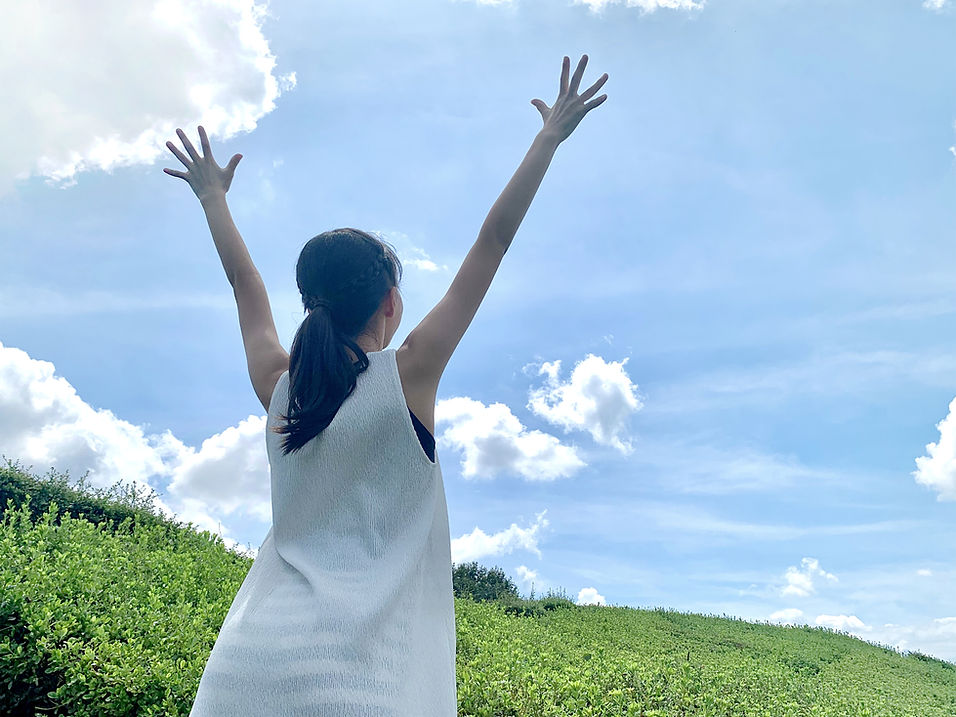 青空に向かって手を広げる女子中学生