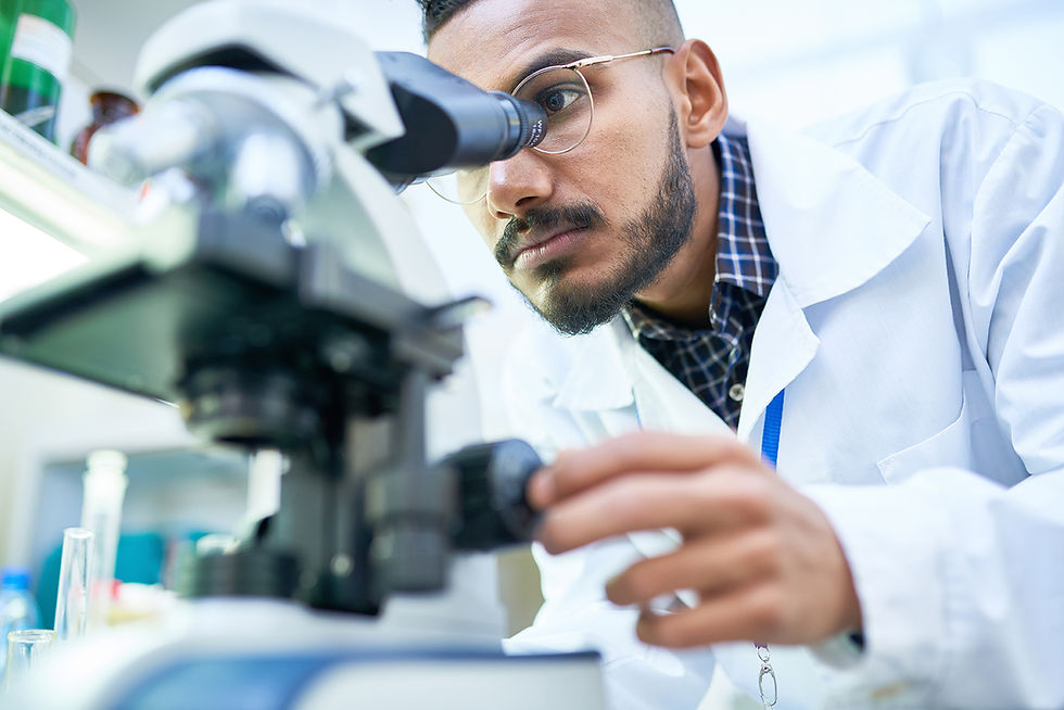 lab technician looking through a microscope, representing scientific research and medical diagnostics.