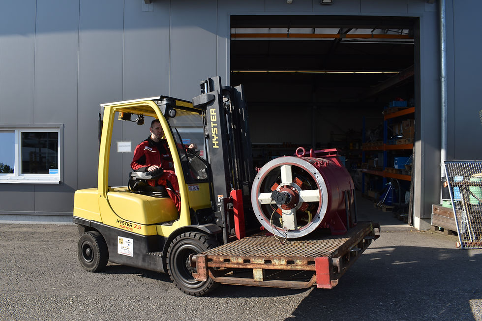 Gabelstapler transportiert einen Elektromotor in einer Werkstatt zur Reparatur.
