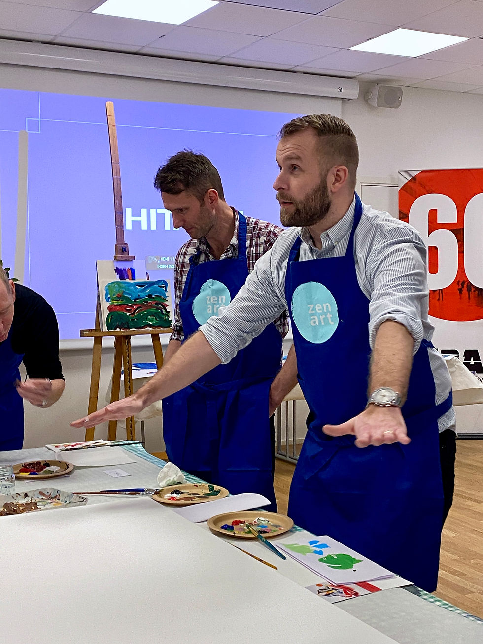 Foto på en man som beskriver ett tema för en tavla på en kreativ workshop med Zenart.
