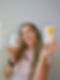 Smiling woman holding tumblers with designs