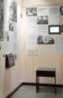 Eine beklebte Holzwand mit Texten über die Flucht der Familie Mann und ein Literaturquiz auf einem Monitor.