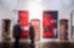 Zwei Menschen vor bedruckten Bannen in eie Ausstellung