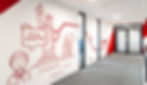 Eine rote Strichgrafik von der Freiheitstatue an der Wand auf einem Flur mit grauem Teppich.