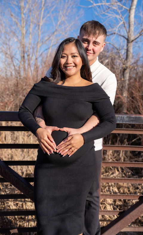 Pregnant couple making a heart shape with their hands, LW Productions