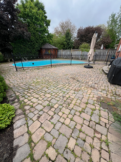 Interlock patio before polymeric sanding in Oakville Ontario showing weed growth joint erosion and unstable paver joints prior to restoration